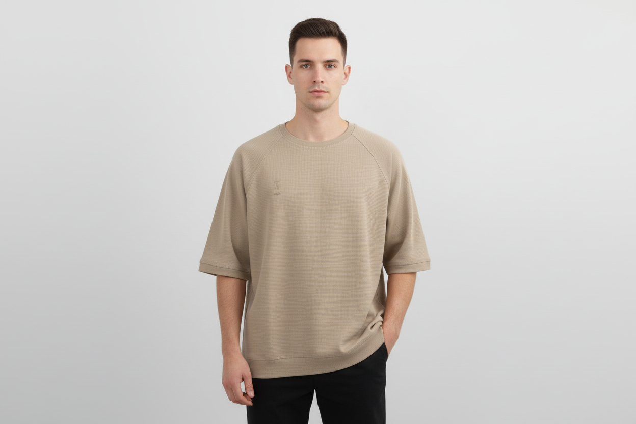 Man wearing a beige t-shirt on a plain background